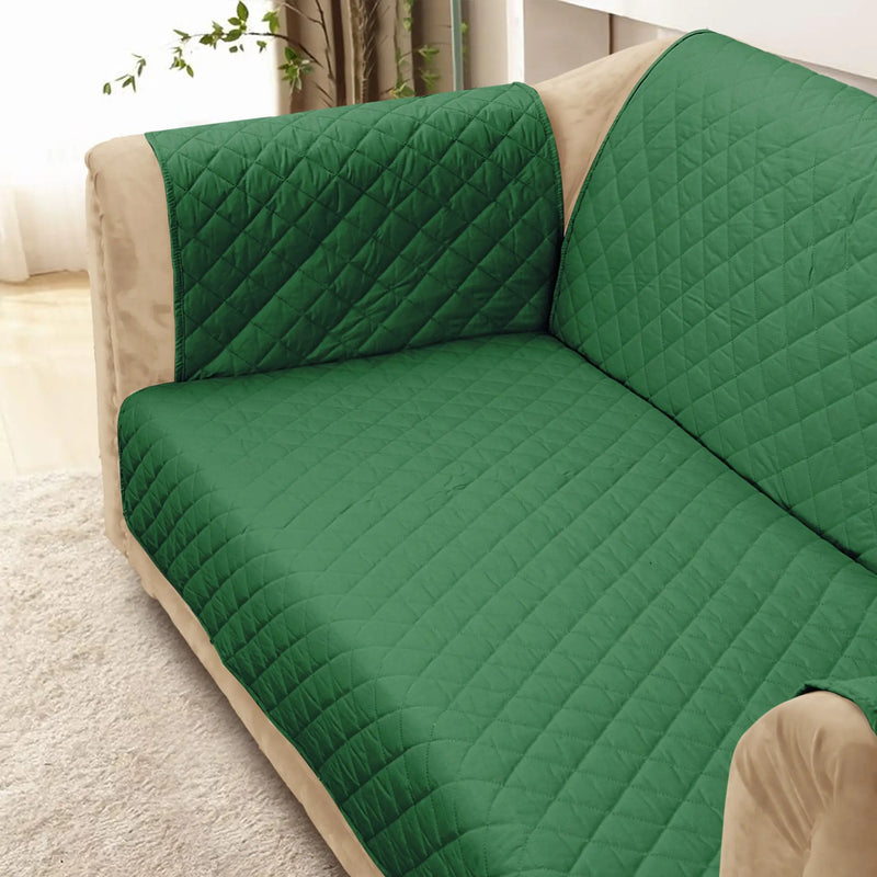 A close-up of a green quilted sofa cover on a couch