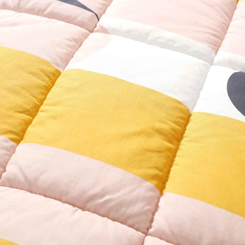 Close-up of a colorful blanket with yellow, pink, and white stripes