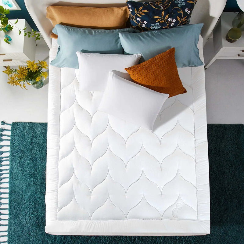 Corner of a white padded mattress with blue base and white piping, showing mattress depth.