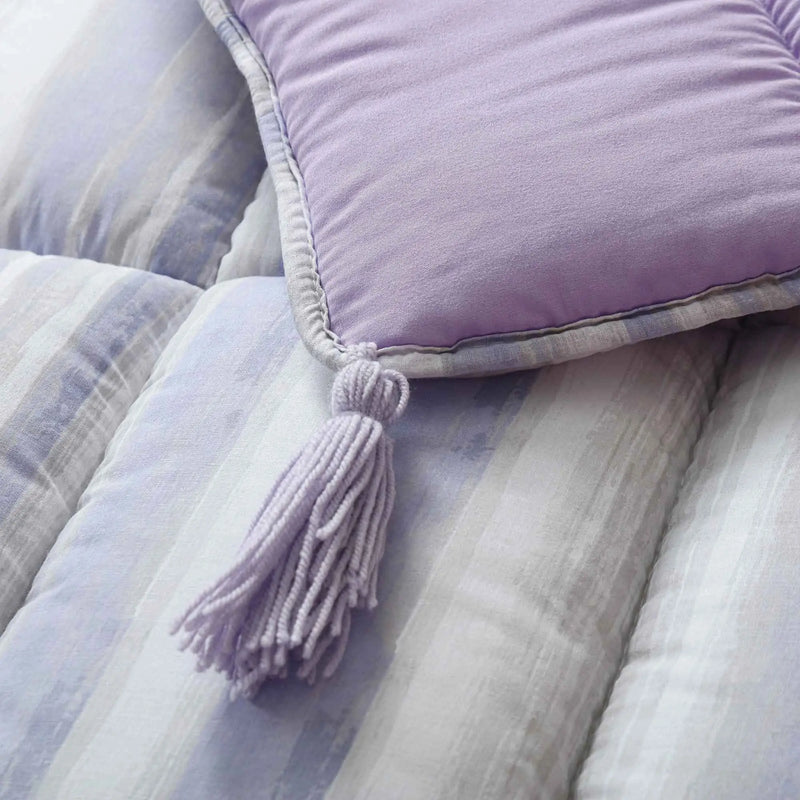 Close-up of purple pillow with tassel