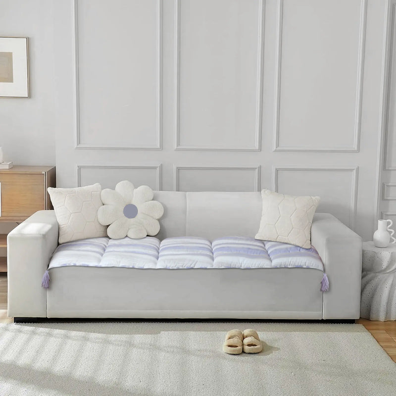 Full view of sofa with white and purple cushions and pillows